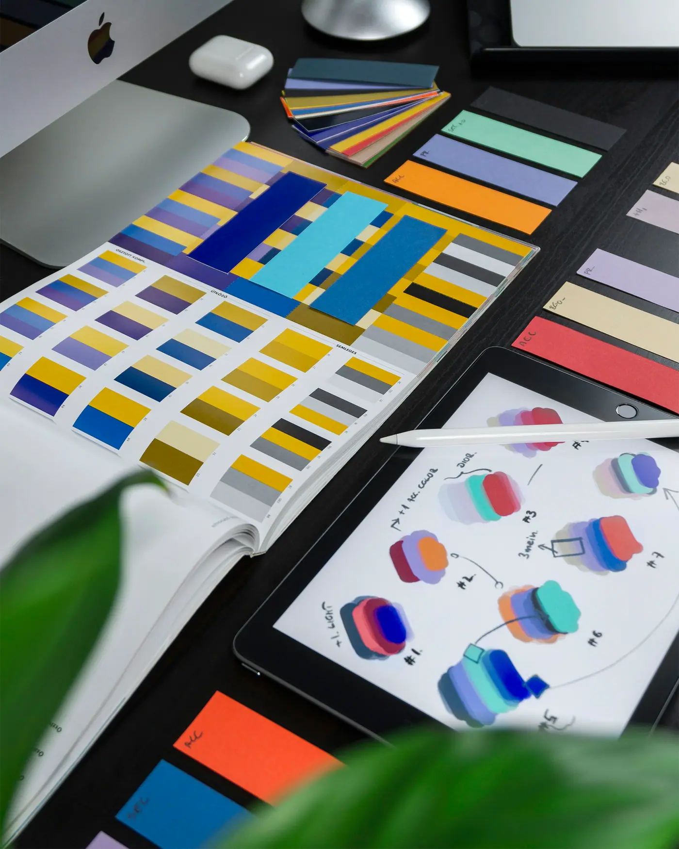 Muestrario de colores y bocetos de diseño gráfico sobre una mesa de trabajo